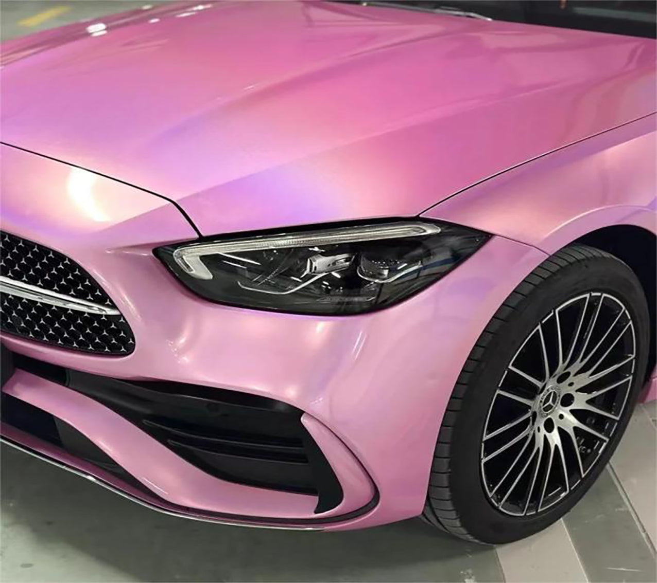 Metallic rainbow laser pink car wrap finish shimmering with prismatic rainbow reflection