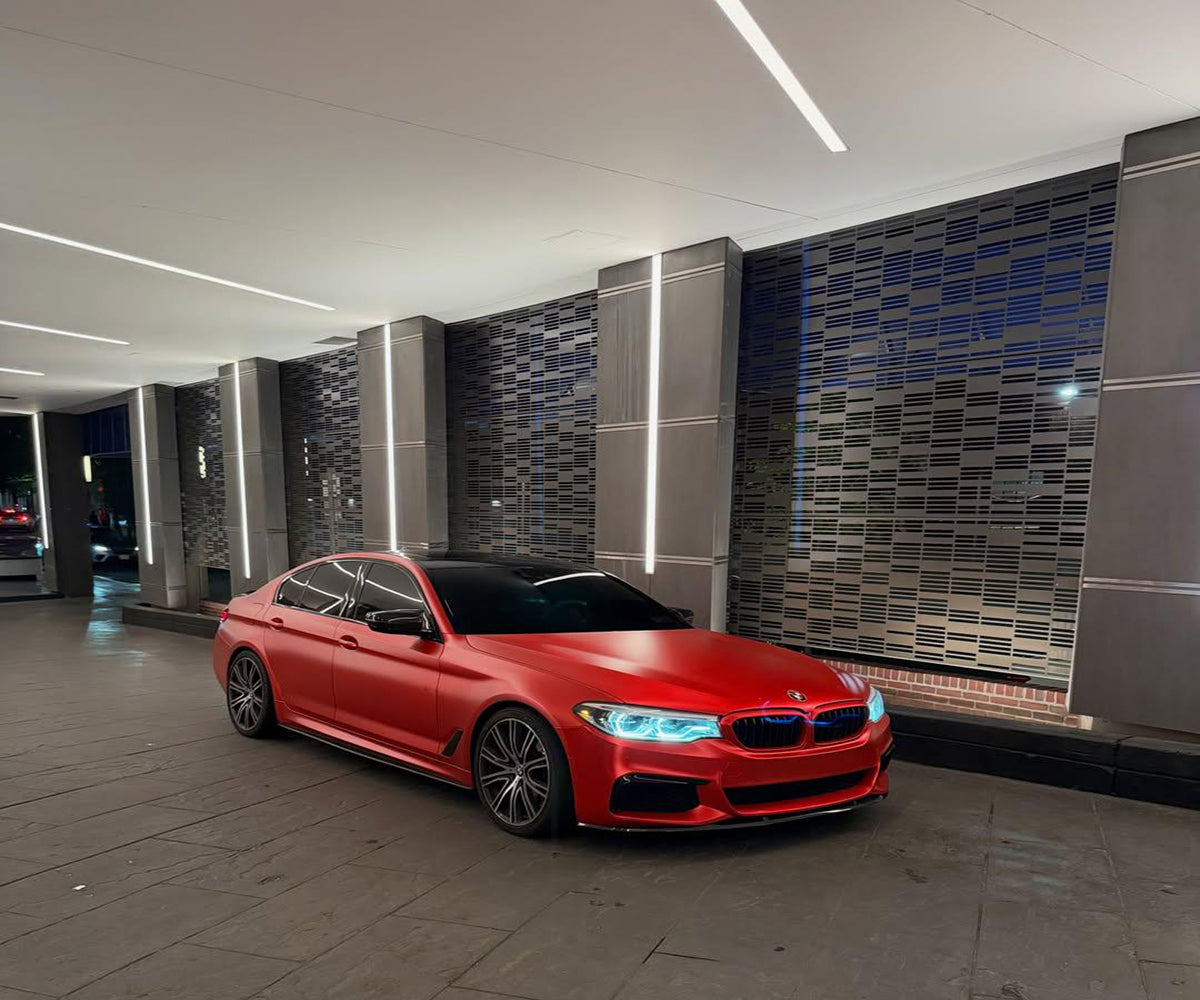 Satin Ceramic Red vinyl wrap highlighting sculpted vehicle body lines