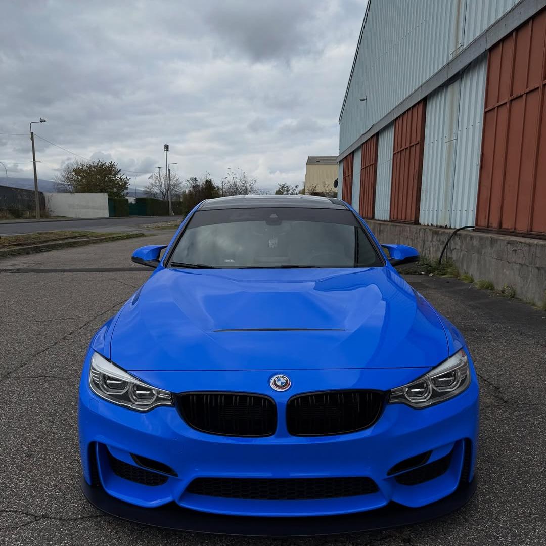 Close-up on a car hood wrapped in premium ALUKOCARWRAP Blue Car Wrap, highlighting the scratch-resistant glossy paint protection.