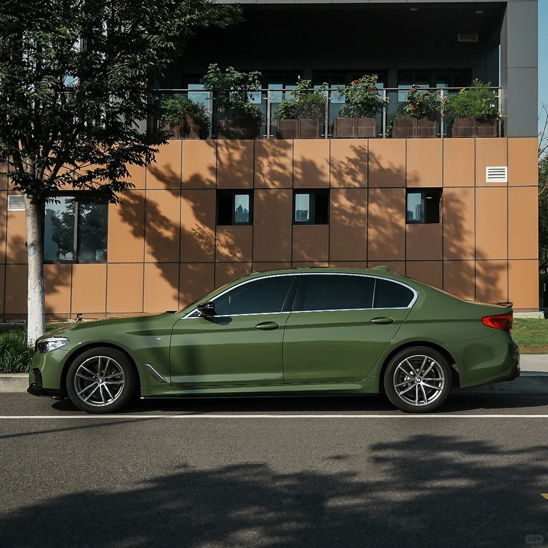 Rugged off-road SUV fully wrapped in ALUKOCARWRAP Army Green Car Wrap, radiating a commanding tactical aesthetic under outdoor sunlight.