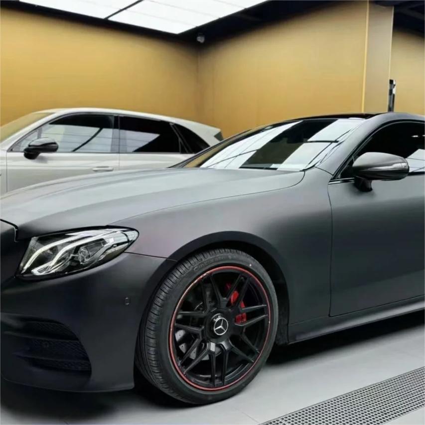 An aggressive widebody supercar radiating a non-reflective volcanic aesthetic in ALUKOCARWRAP matte metallic car wrap under a stark overcast sky.