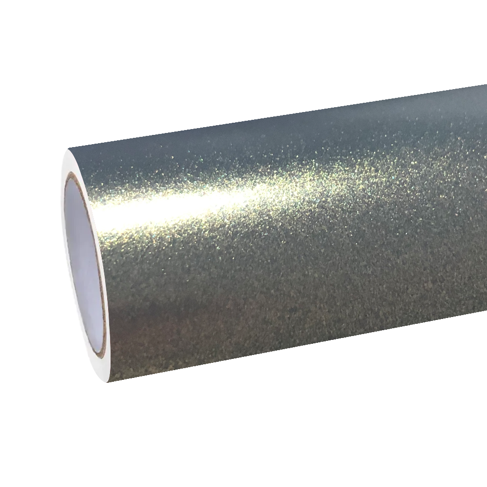Diffused warehouse lighting bouncing off the satin anthracite undertone of ALUKOCARWRAP grey gold car wrap film to reveal frozen champagne sparkles.