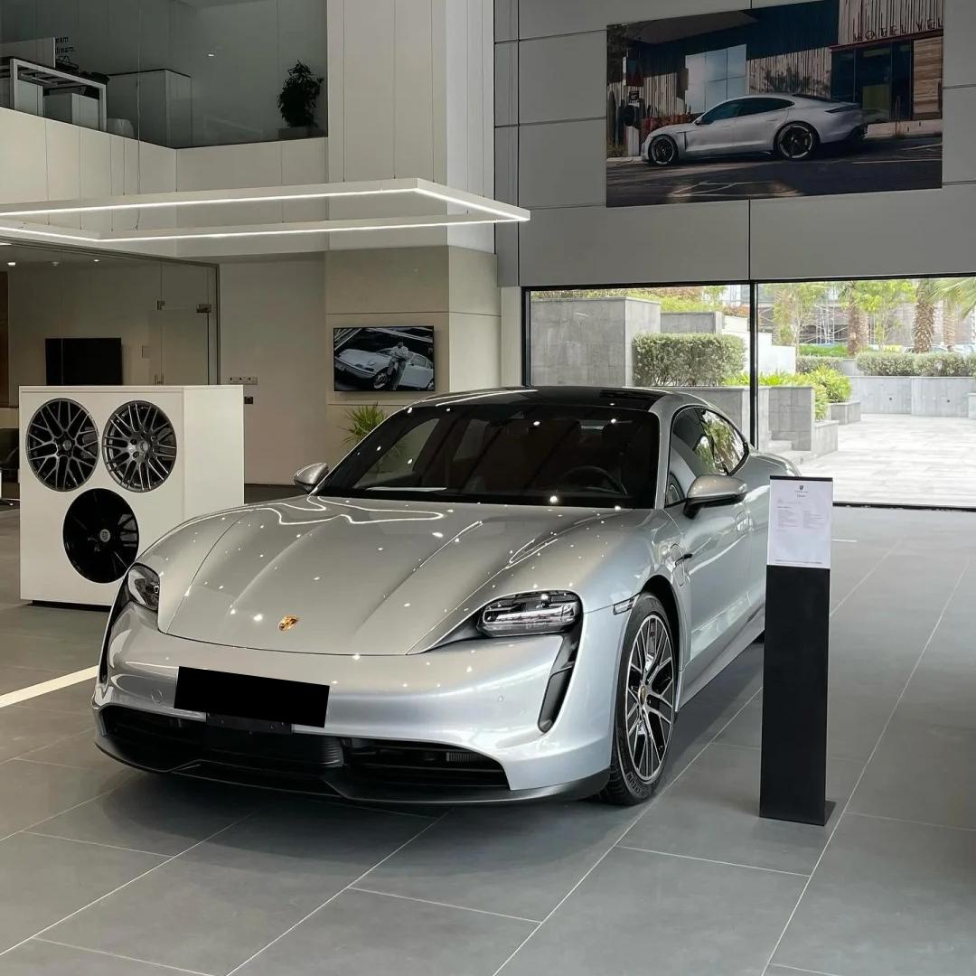 Liquid-metal reflection on the rounded muscular fenders of a sports car wrapped in ALUKOCARWRAP Gloss Grey Car Wrap.