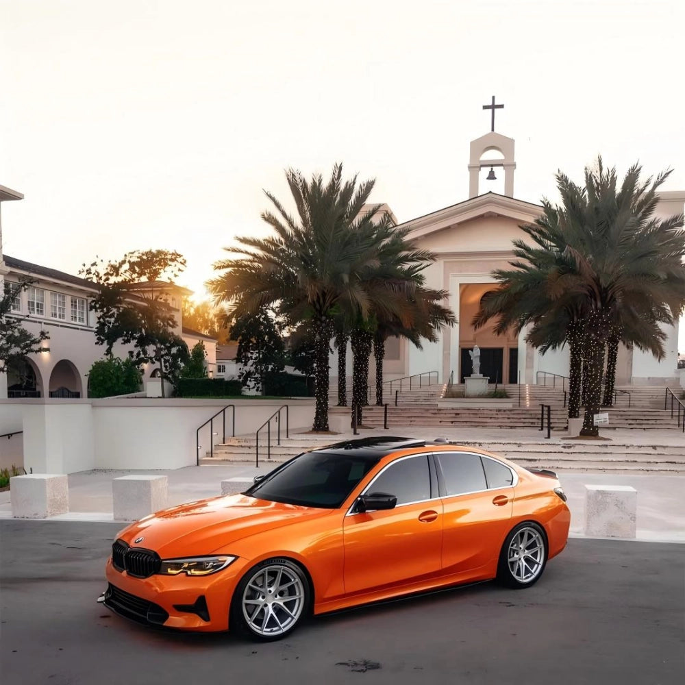 Full vehicle color change with gloss metallic fiery orange car vinyl wrap on a luxury sports car.