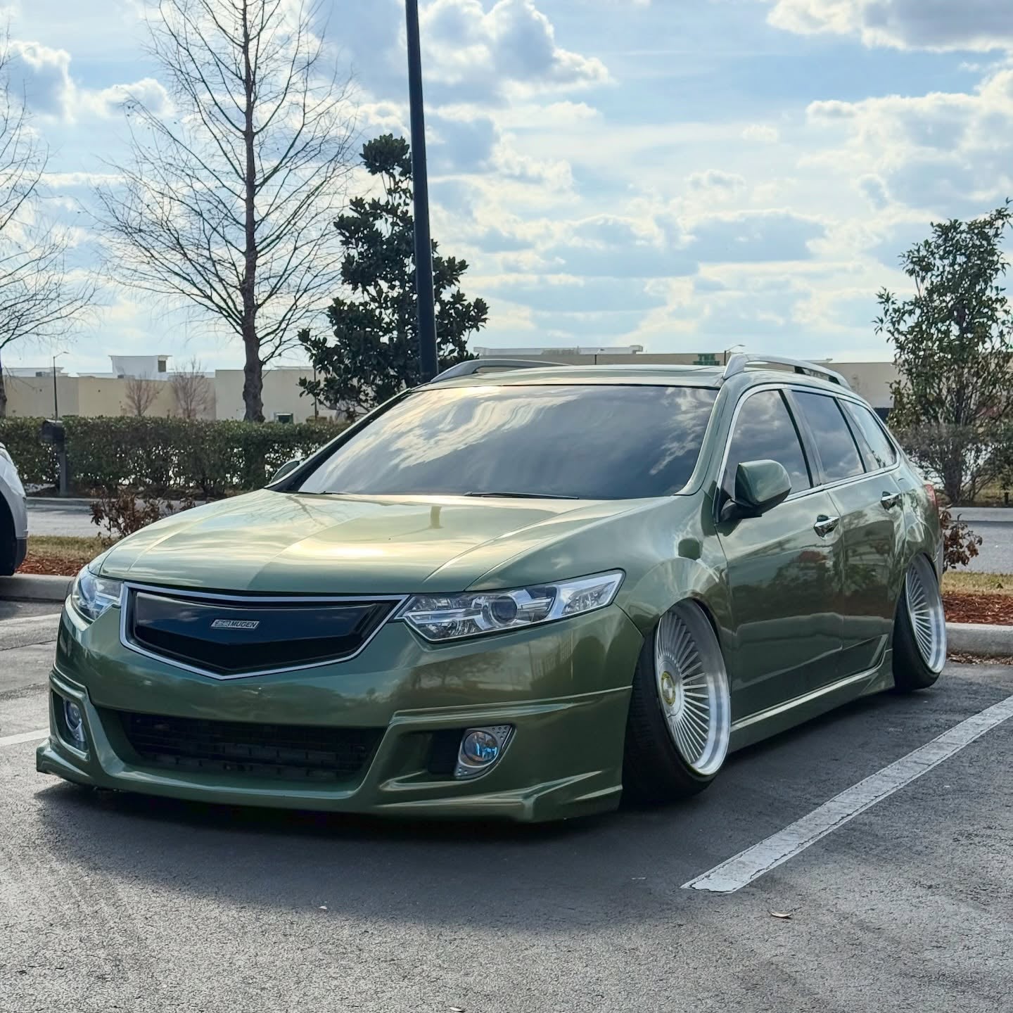 ALUKOCARWRAP Gloss Metallic Olive Green Car Vinyl Wrap PET installed on vehicle side panel under natural sunlight