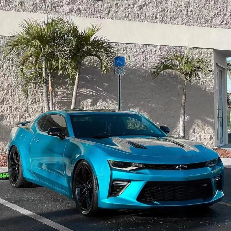 Luxury sports car wrapped in gloss metallic atomic teal wrap, looking as eye-catching as holographic rainbow laser vinyl.