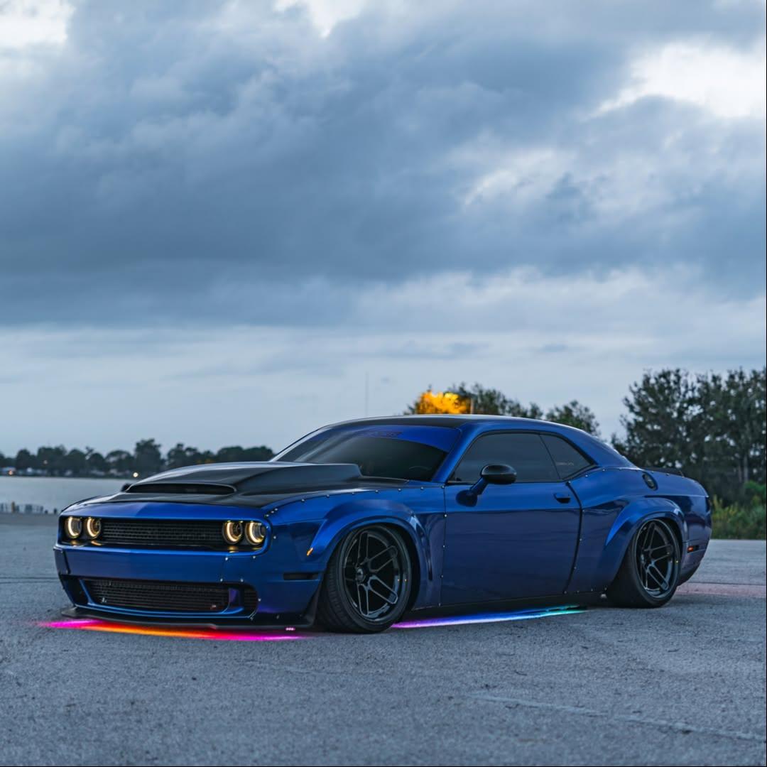 ALUKOCARWRAP Blueberry Car Wrap capturing sharp evening neon light leaks on an aggressive sports car fender line.
