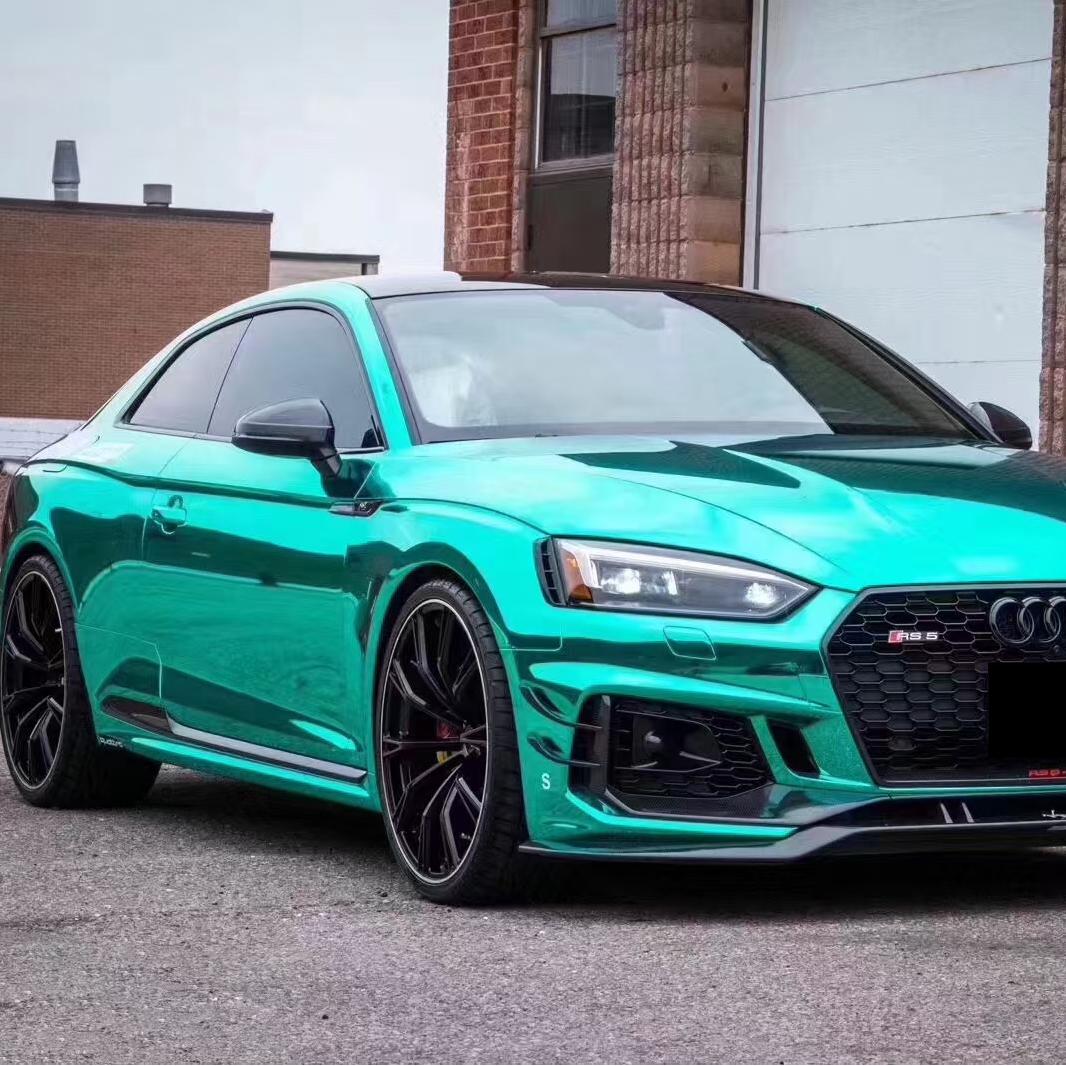 Sunlight reflecting off a hypercar wrapped in ALUKOCARWRAP Gloss Mirror Chrome Green Car Vinyl Wrap PET, revealing a flawless mirror chrome car wrap sheen.