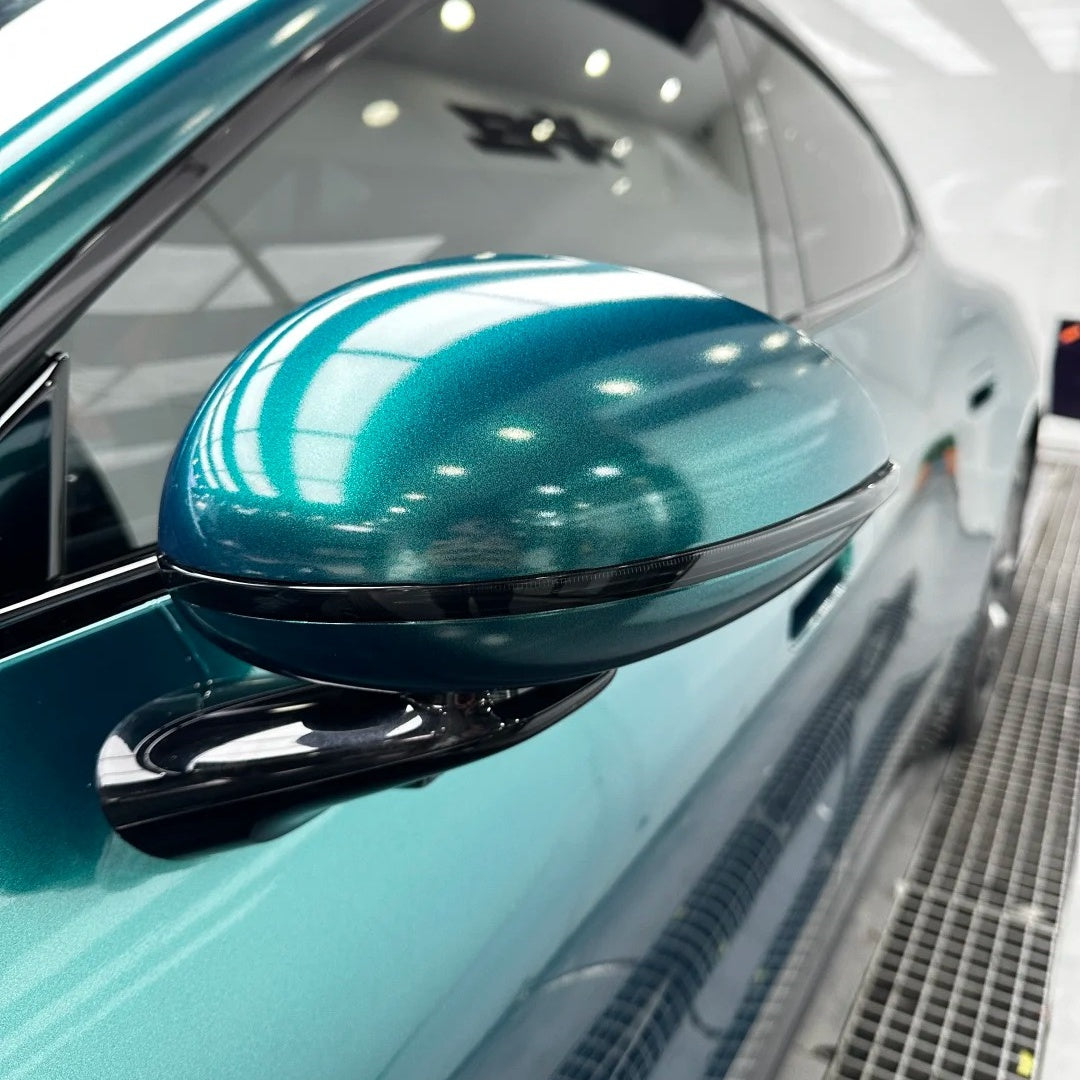 Macro close-up of a luxury car fender wrapped with ALUKOCARWRAP Sea Green Car Wrap, highlighting a mirror-like gloss finish with zero orange peel.
