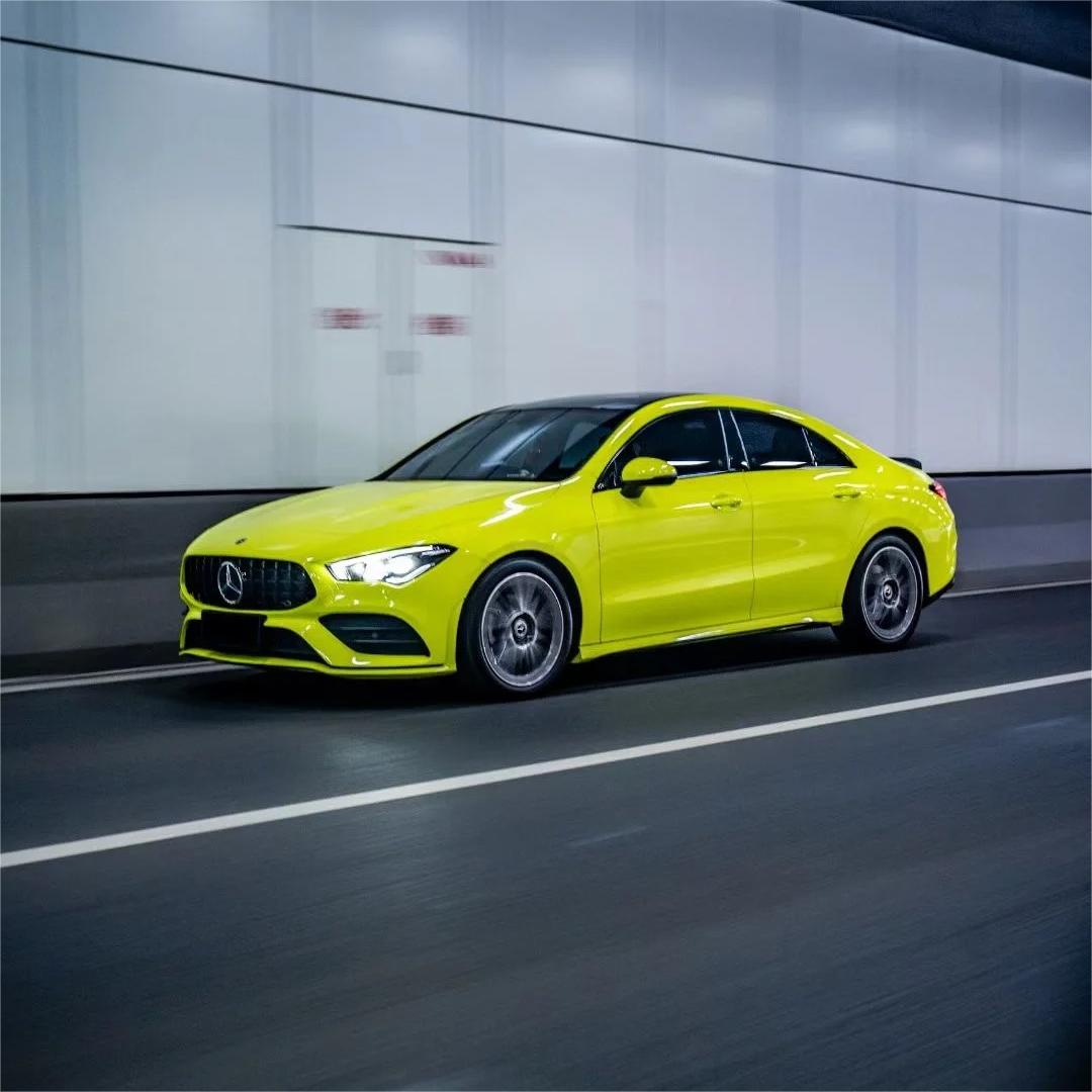 A modified performance vehicle with a premium green car wrap in ALUKOCARWRAP Gloss Acid Green parked outdoors, highlighting the intense neon metallic shine under daylight.
