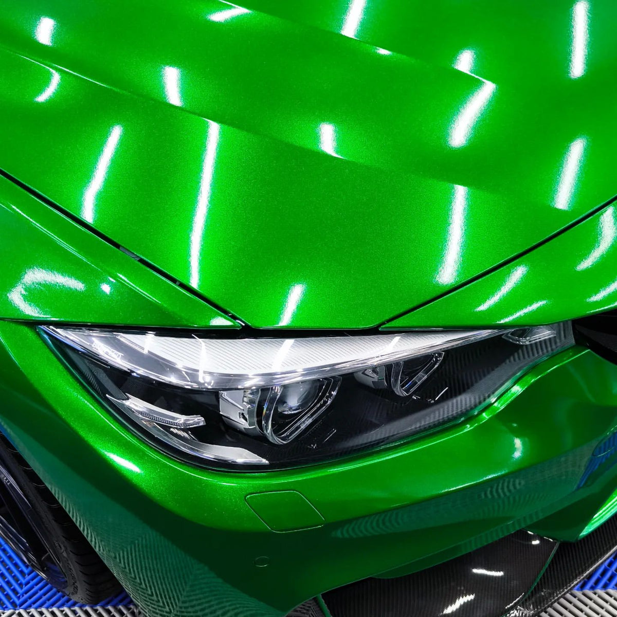 Precision edge-tucking detail of ALUKOCARWRAP Gloss Metallic Diamond Lizard Green Car Vinyl Wrap around a vehicle side-view mirror