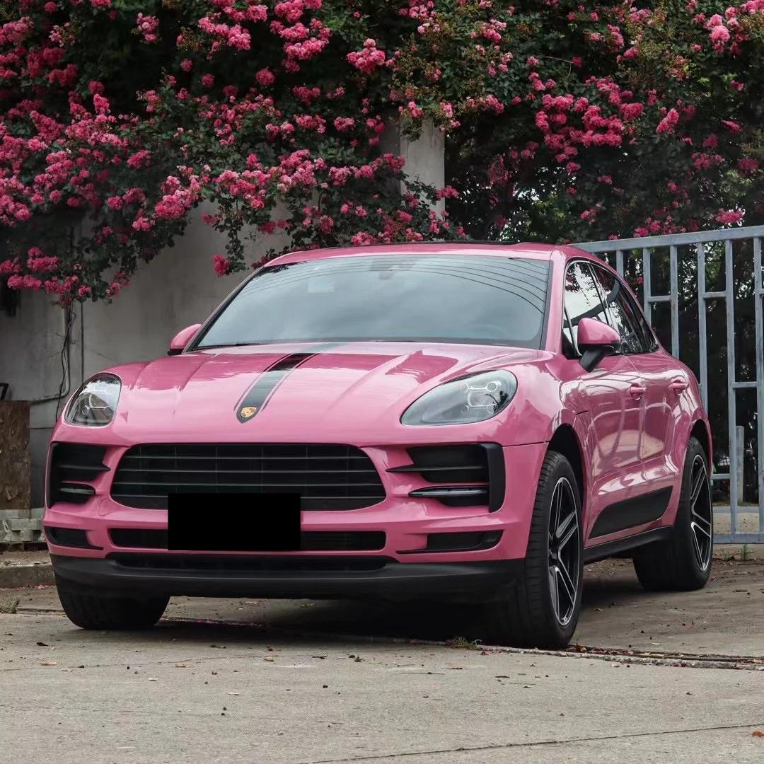 Full vehicle body display of a luxury Euro coupe wrapped in Tulip Pink gloss vinyl, parked inside a modern brightly lit vehicle studio.