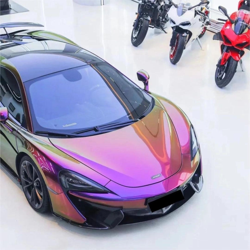 Luxury vehicle wrapped in gloss metallic chameleon yellow purple vinyl wrap, displaying a vibrant pearl color shift finish.