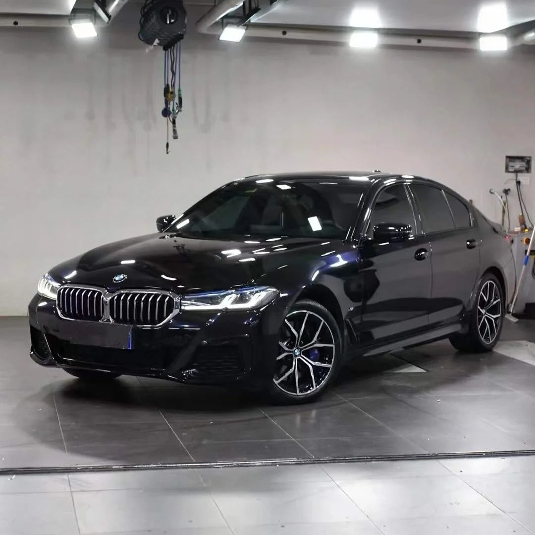 Sunlight reflection on metallic micro-glitter flakes of Glossy Metallic Glitter Black Blue Vinyl Wrap on a car body.