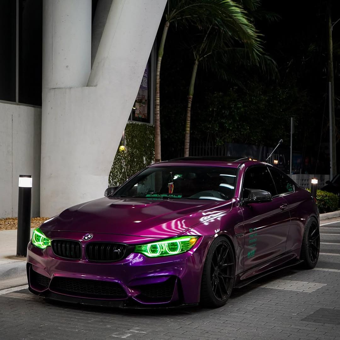 A luxury sport sedan wrapped in Gloss Metallic Grape Purple Car Vinyl Wrap PET, showing rich deep violet metallic tones.