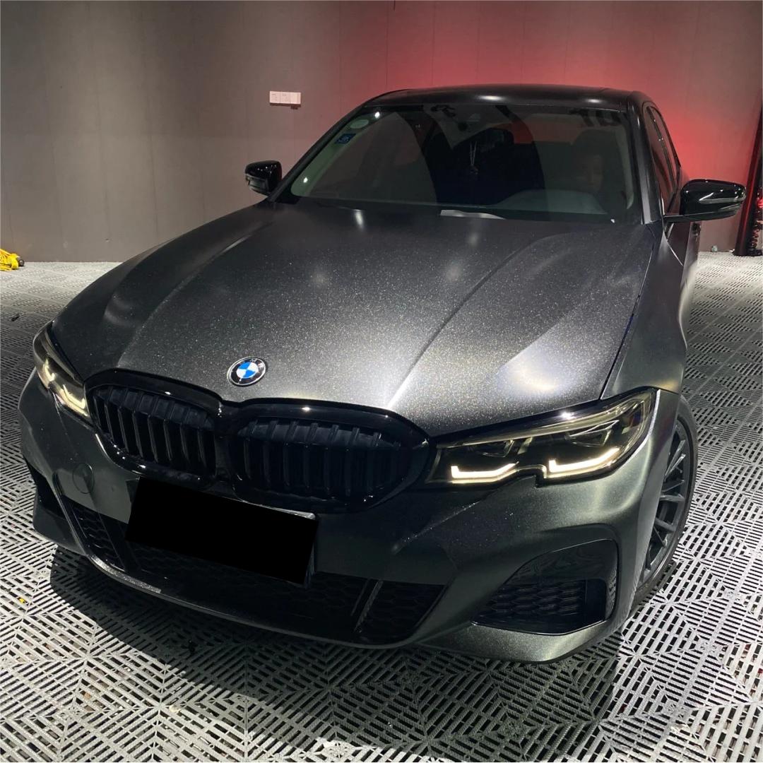 Diamond black car wrap structural view displaying micro-crystalline dark specks and high density gloss carbon fleck distribution.