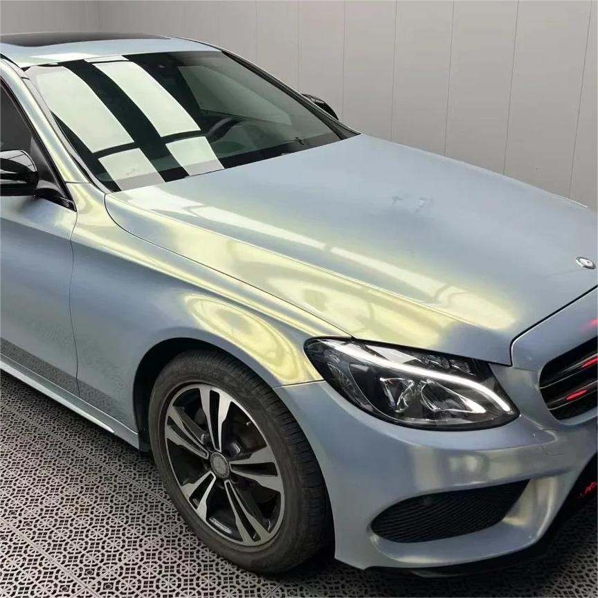 Intense solar glare fracturing into a hyper-reflective crystal shimmer across curved panels applied with ALUKOCARWRAP gloss metallic car wrap matrix.