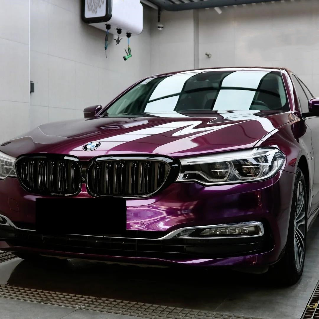 ALUKOCARWRAP premium gloss dark purple car wrap on a luxury sports car, showcasing smooth mirror-like finish.