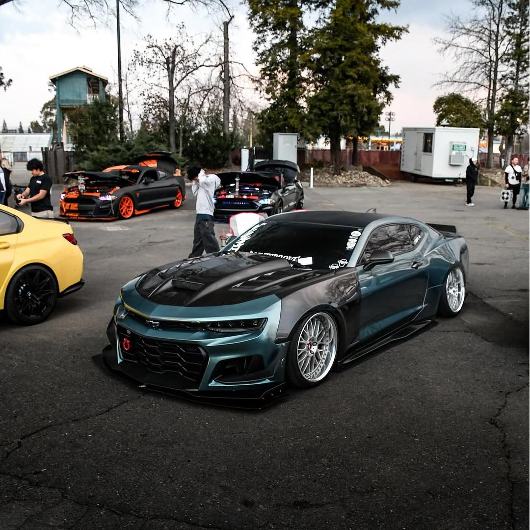 A luxury supercar driving during golden hour fully wrapped in Interstellar Green Car Wrap, capturing the shifting deep cosmic emerald shades and metallic glitter.