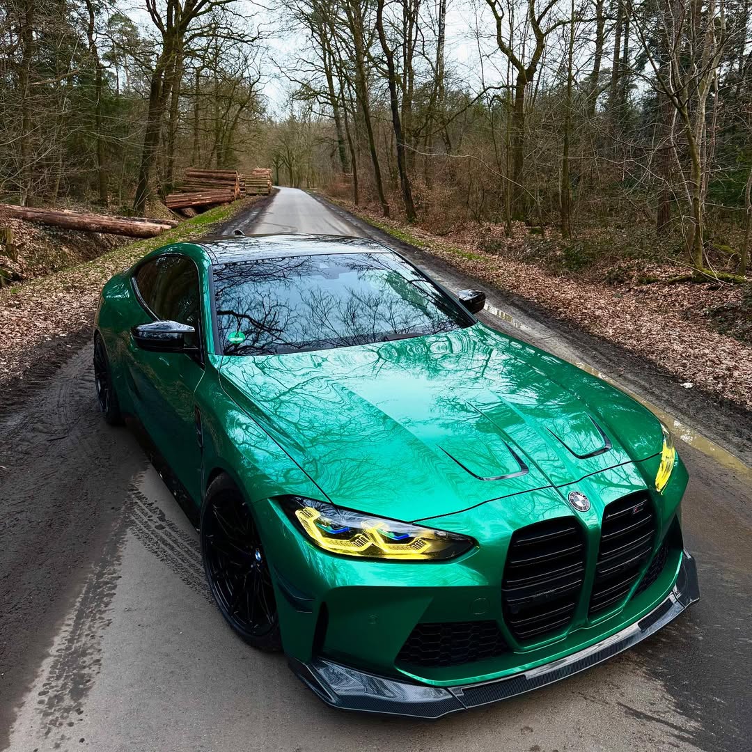 A high-performance sports sedan wrapped in Gloss Metallic Isle Of Man Green Car Vinyl Wrap, capturing deep jade paint gloss.