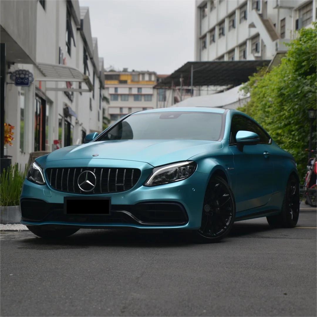 Shadowy studio angle of a luxury sedan wrapped in ALUKOCARWRAP Matte Metallic Lake Blue Car Vinyl Wrap, highlighting a frosty matte blue car wrap finish.