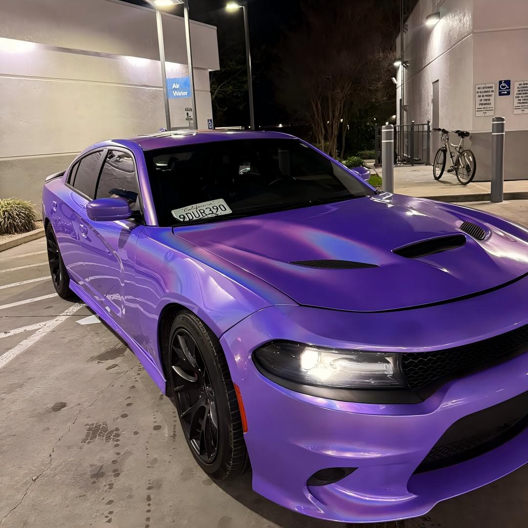 Vibrant rainbow laser reflections on a car body curve wrapped in Gloss Metallic Light Purple Car Vinyl Wrap material.