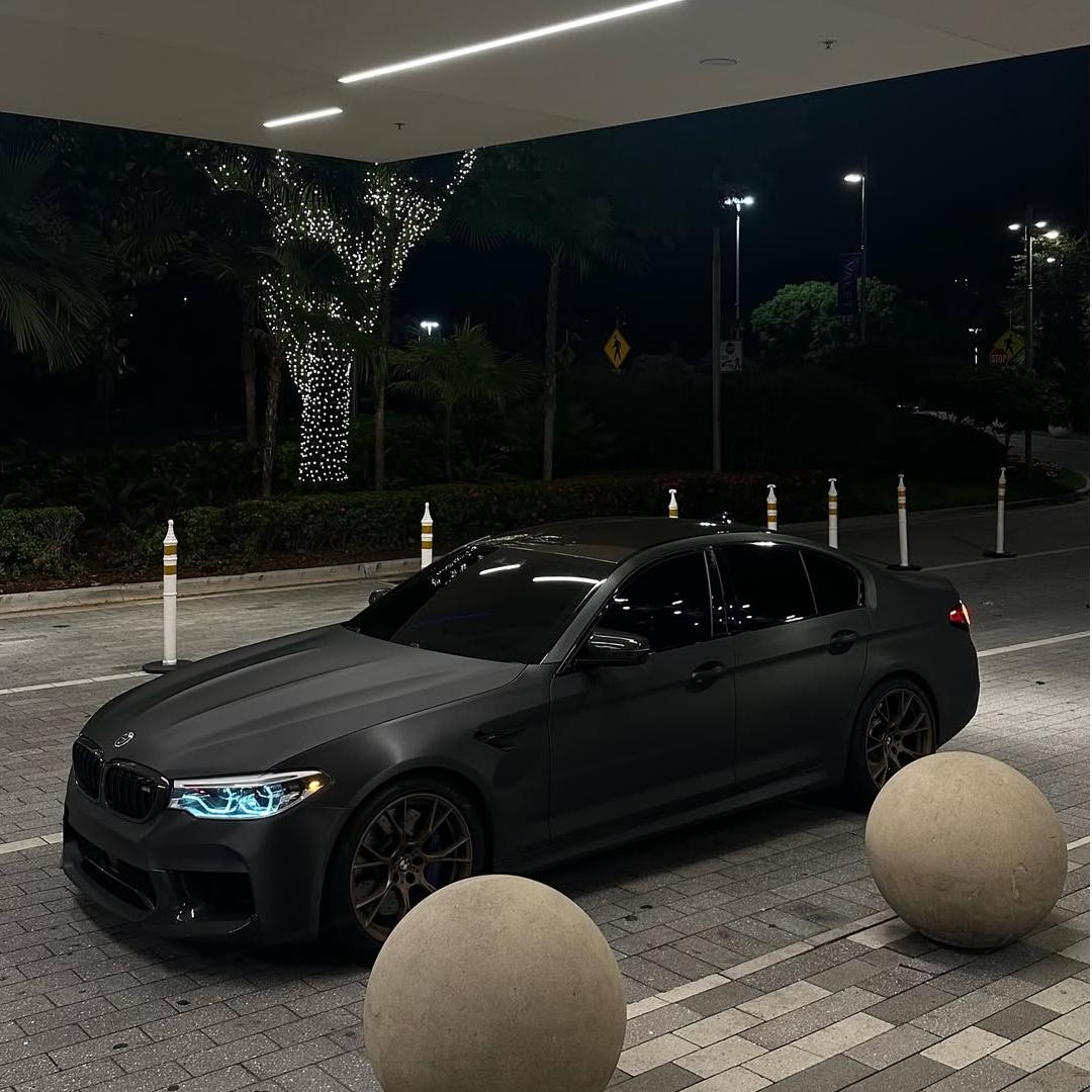 A stealth sports car wrapped in Matte Metallic Brushed Black Car Vinyl Wrap, showcasing a textured dark industrial finish.
