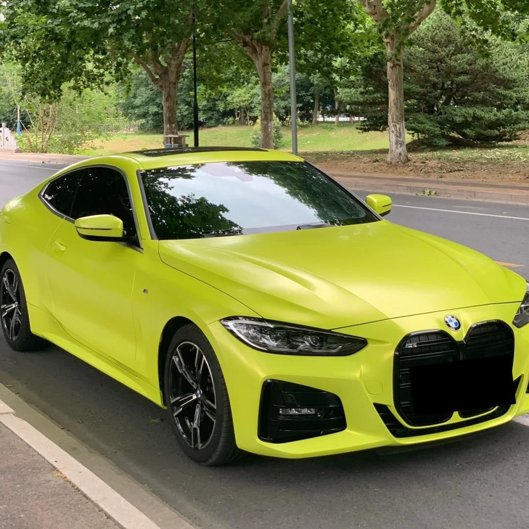 Close-up on a hood capturing the neon glow and distinctive texture of ALUKOCARWRAP fluorescent yellow car wrap with a premium matte metallic car wrap texture.
