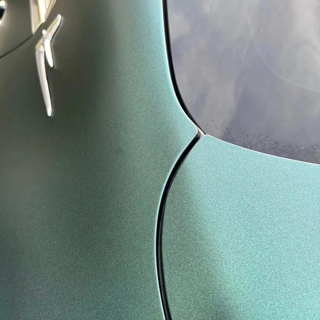 Flawless curvature adaptation of an ALUKOCARWRAP matte satin car wrap over complex body lines, emphasizing dense emerald shading.