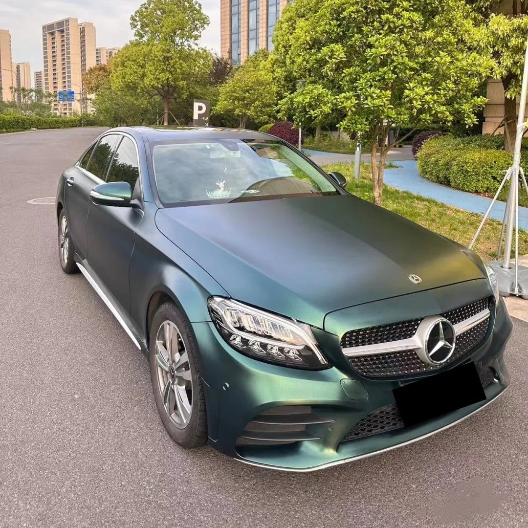 Organic luxury aesthetic on a grand tourer draped in ALUKOCARWRAP matte green car wrap, defining a custom metallic green car wrap silhouette.