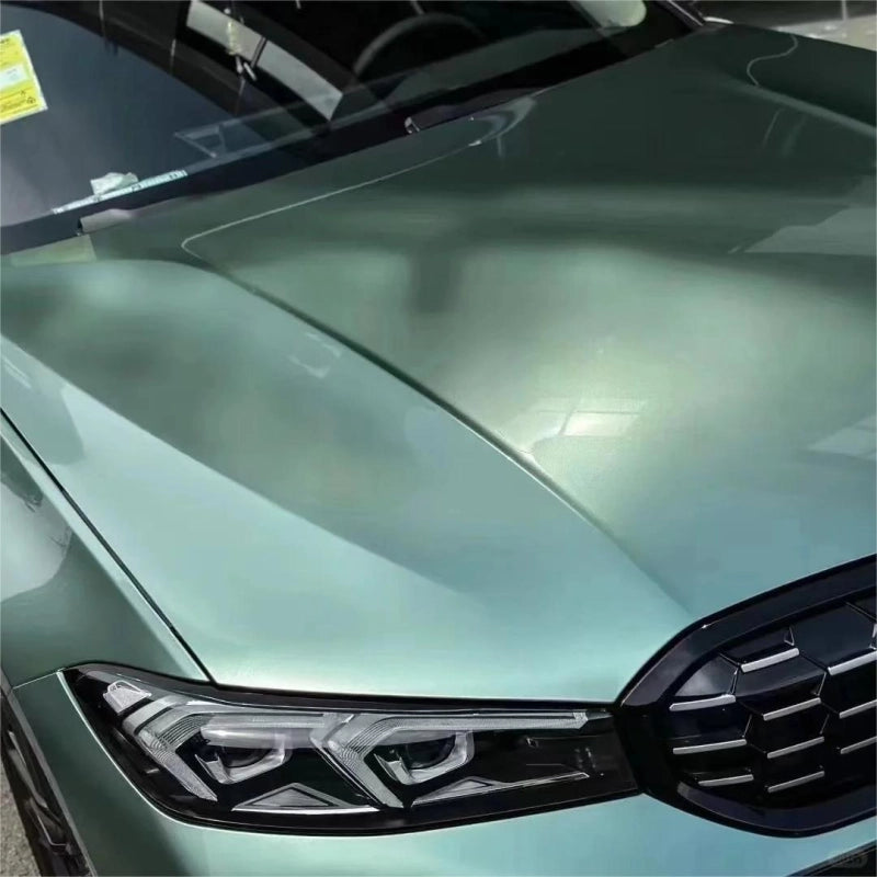Close inspection of metallic Francesca Green car vinyl wrap Ferrari PET texture, showcasing intense exotic metallic flakes.