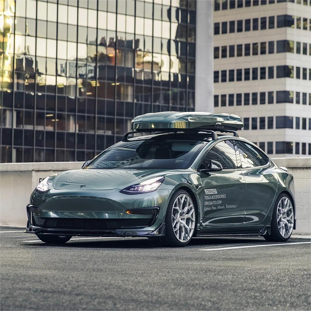 ALUKOCARWRAP Fir Green Car Wrap enveloping an exotic sports sedan parked amidst rugged natural scenery to show off the organic evergreen hue.