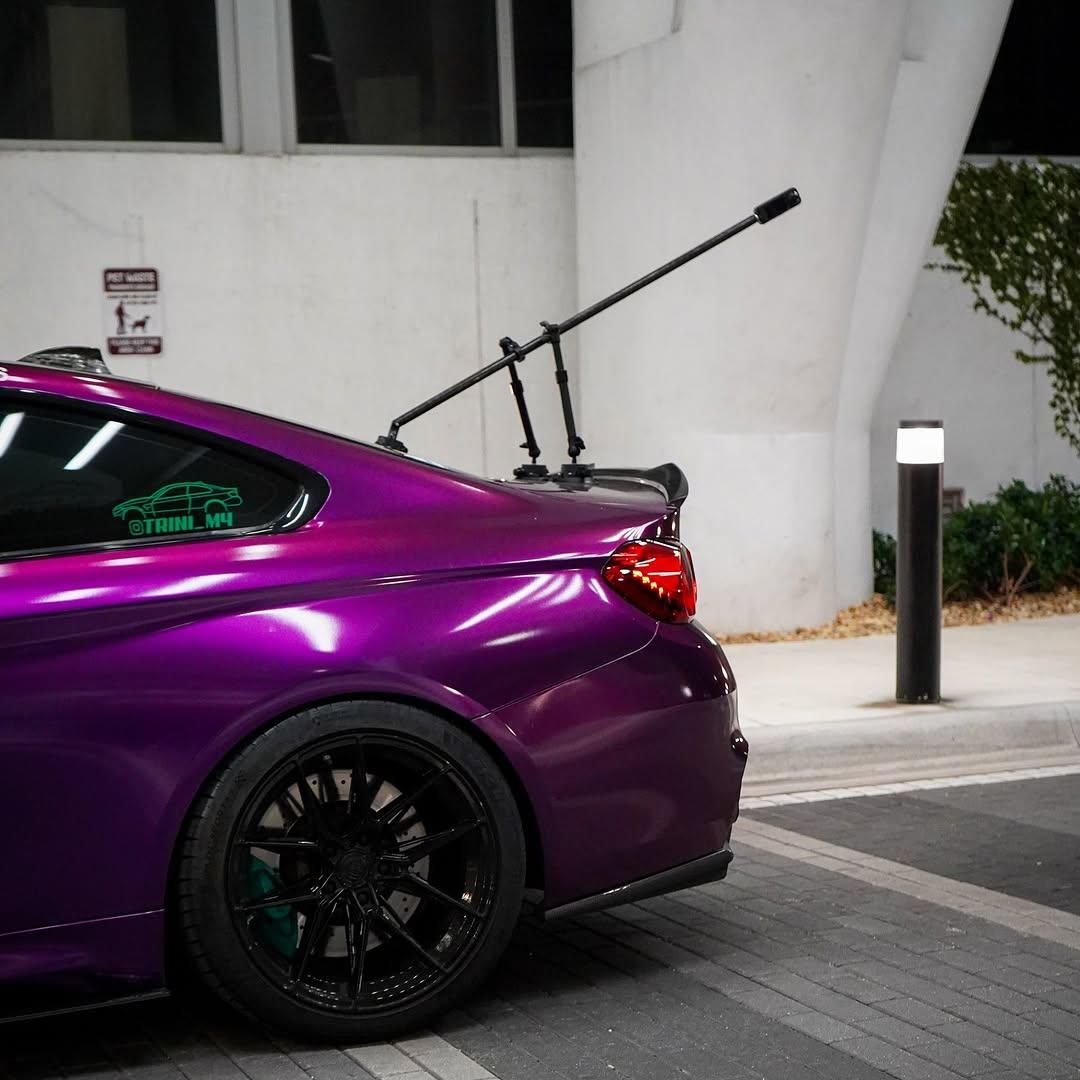 Sunlight gloss reflection on metallic flakes of a car hood wrapped in Gloss Metallic Grape Purple Car Vinyl Wrap PET.