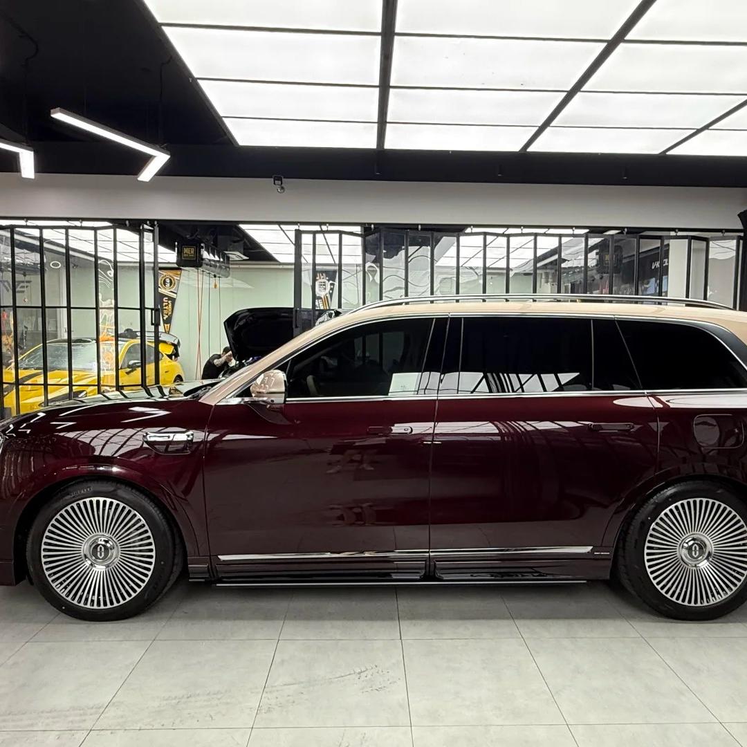 Luxury sports sedan fully wrapped in ALUKOCARWRAP Plum Red Car Wrap, showcasing a stunning high-gloss metallic finish under bright outdoor sunlight.