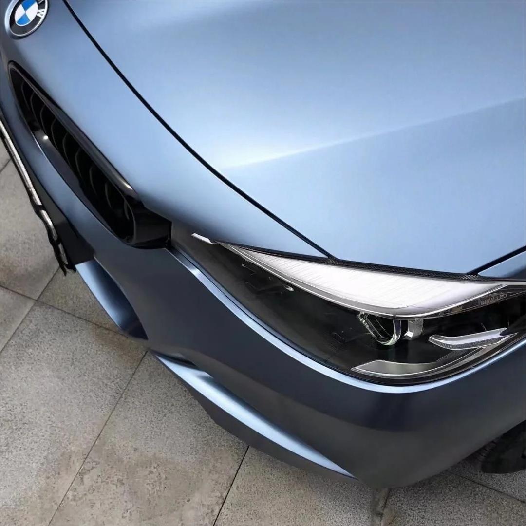 Severe body creases capturing a seamless application of ALUKOCARWRAP metallic blue car wrap, accentuating a deep tempest shadow.