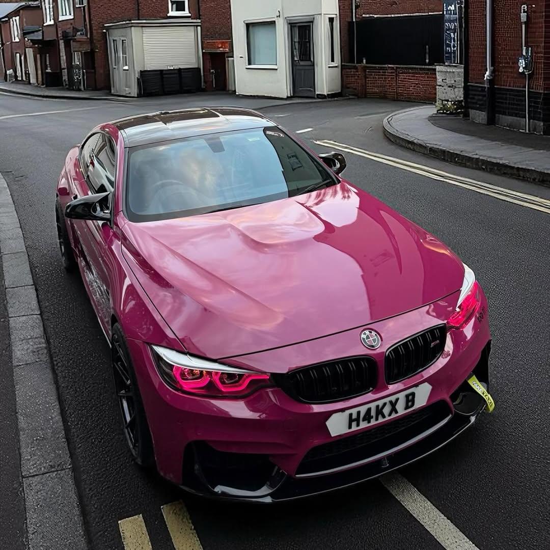 A premium sports car fully wrapped in Gloss Ruby Star Car Vinyl Wrap PET, showing a retro vibrant pink-red paint look.
