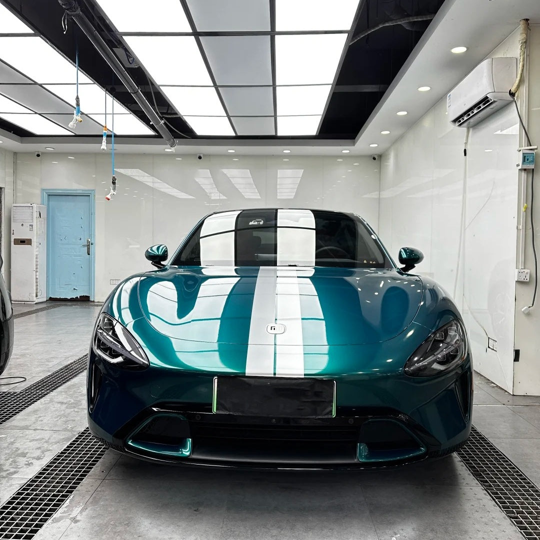 Full vehicle display wrapped in ALUKOCARWRAP Chameleon Deep Green Car Wrap, illustrating the dynamic metallic color shift under ambient showroom lighting.