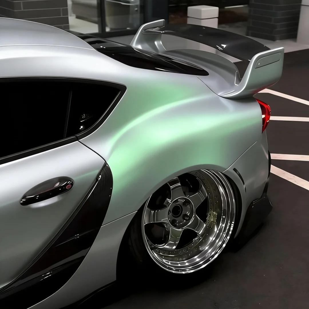 Macro photo of gloss green car wrap edge on a premium PET backing showing zero visual distortion and flawless metallic finish.