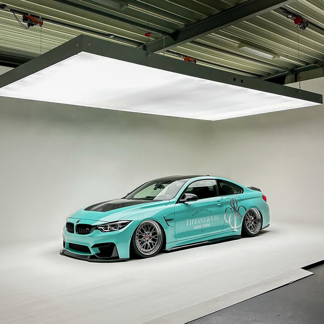 A stylish electric car wrapped in Gloss Sparkle Glitter Tiffany Blue Car Vinyl Wrap, shining with diamond star flakes.