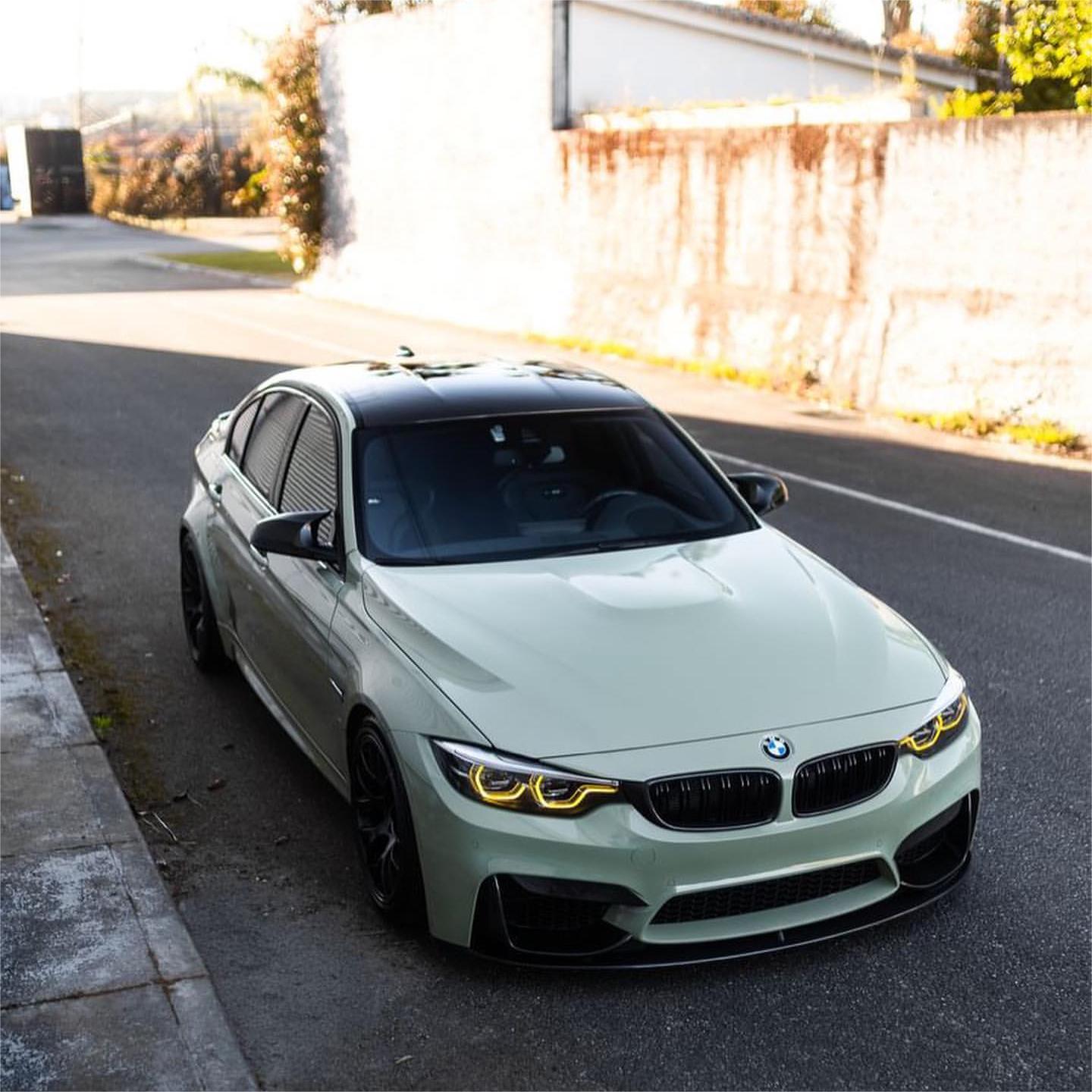 Close-up of a luxury sports sedan fully wrapped in ALUKOCARWRAP gloss light khaki green car vinyl wrap, showcasing a flawless mirror-like finish under bright daylight.